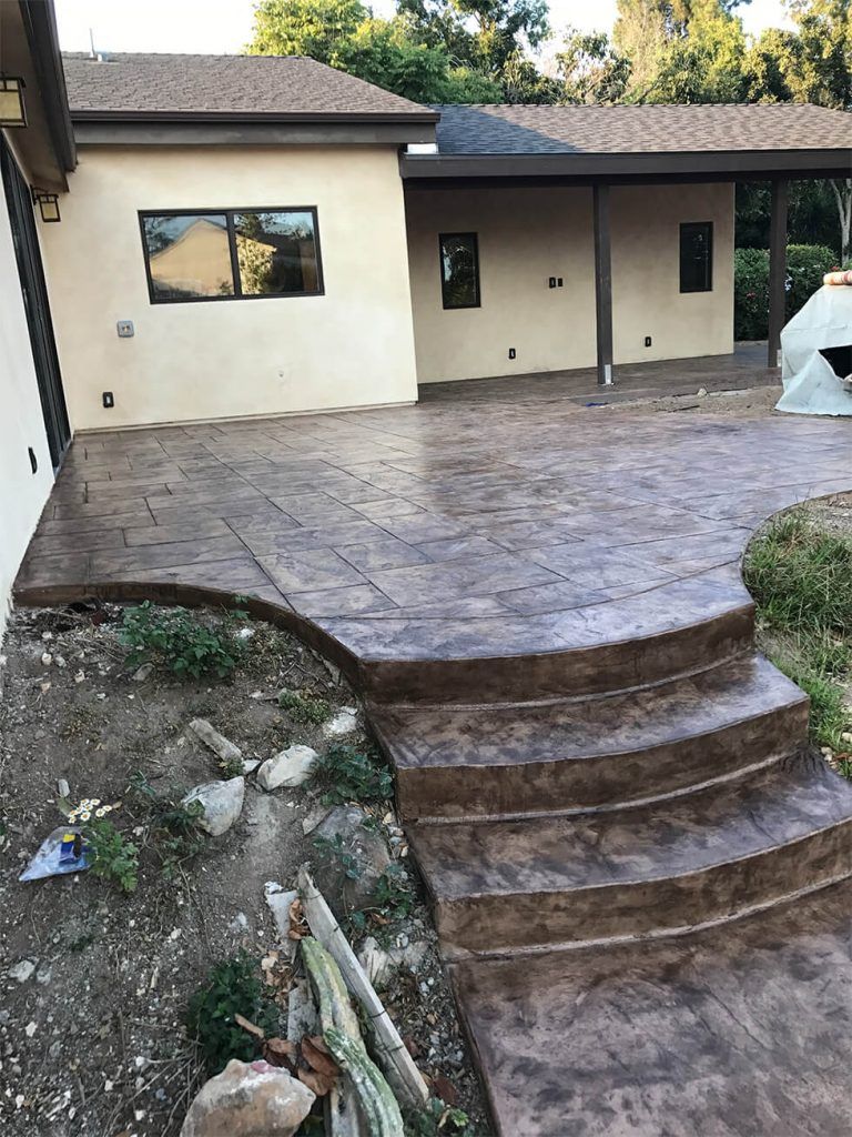 A concrete patio with curved steps leading down.