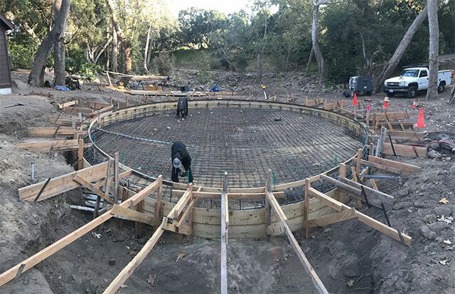 Construction site with circular concrete foundation.