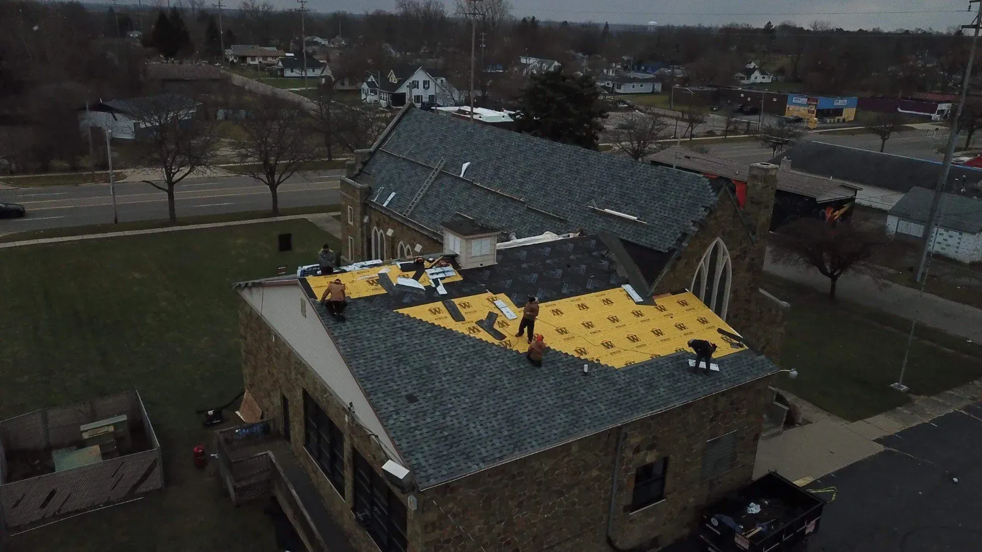 An aerial view of a church roof being installed.