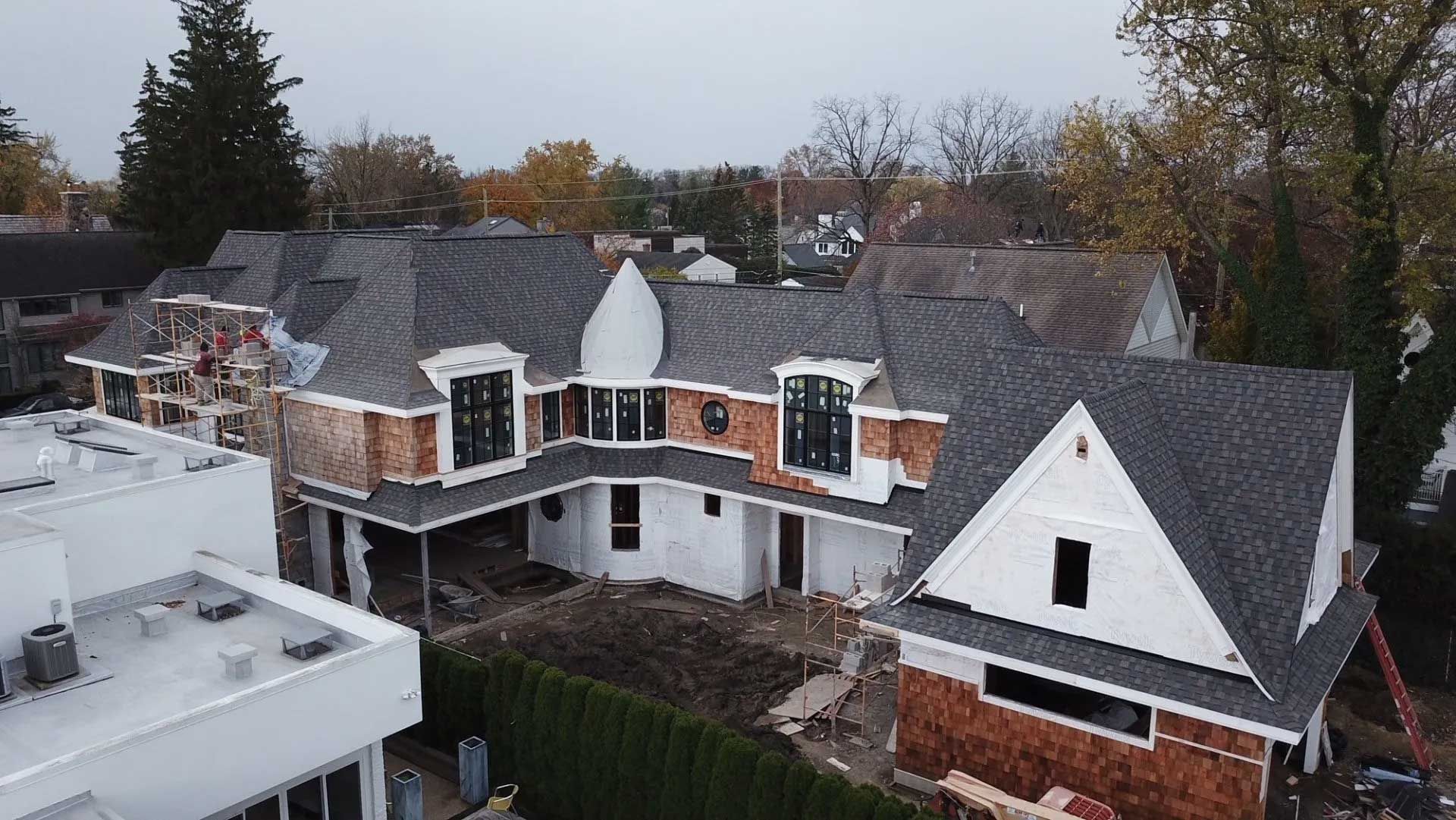 An aerial view of a house under construction in a residential area.