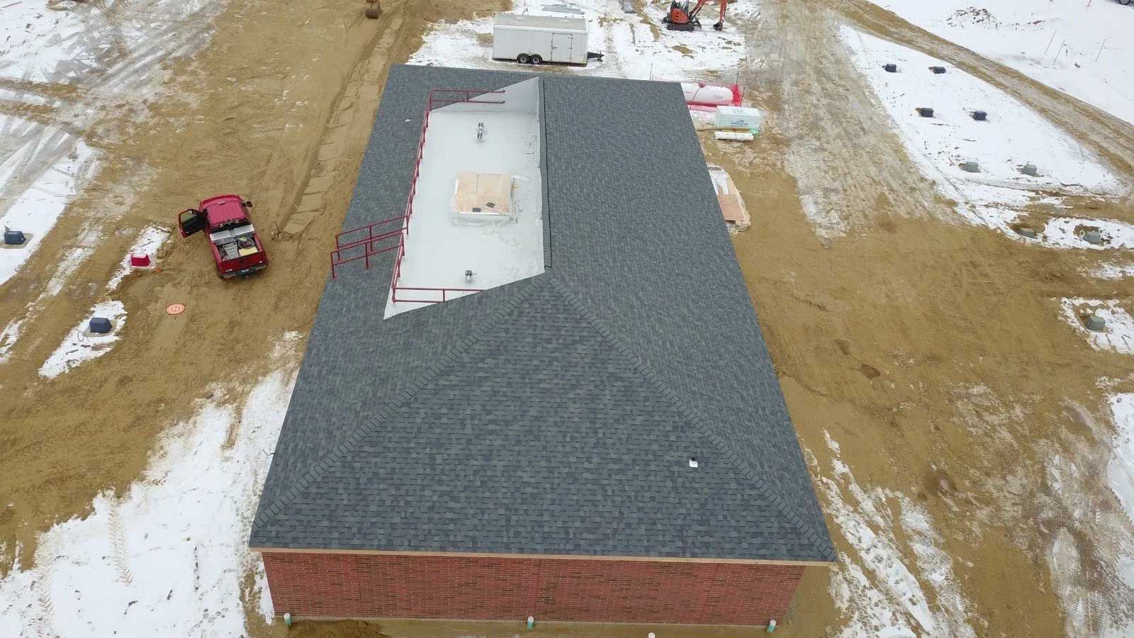 An aerial view of a building under construction in the snow.