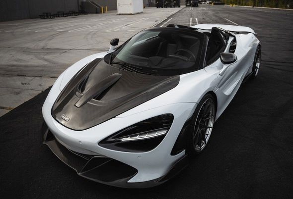 White McLaren 720S Spider convertible with carbon fiber hood, parked on asphalt.