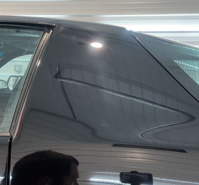 A man is looking at a car in a garage