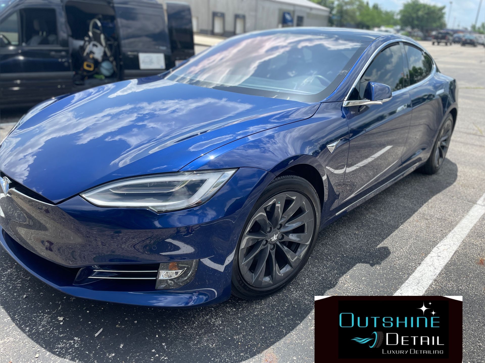 Blue Tesla car parked outside; 