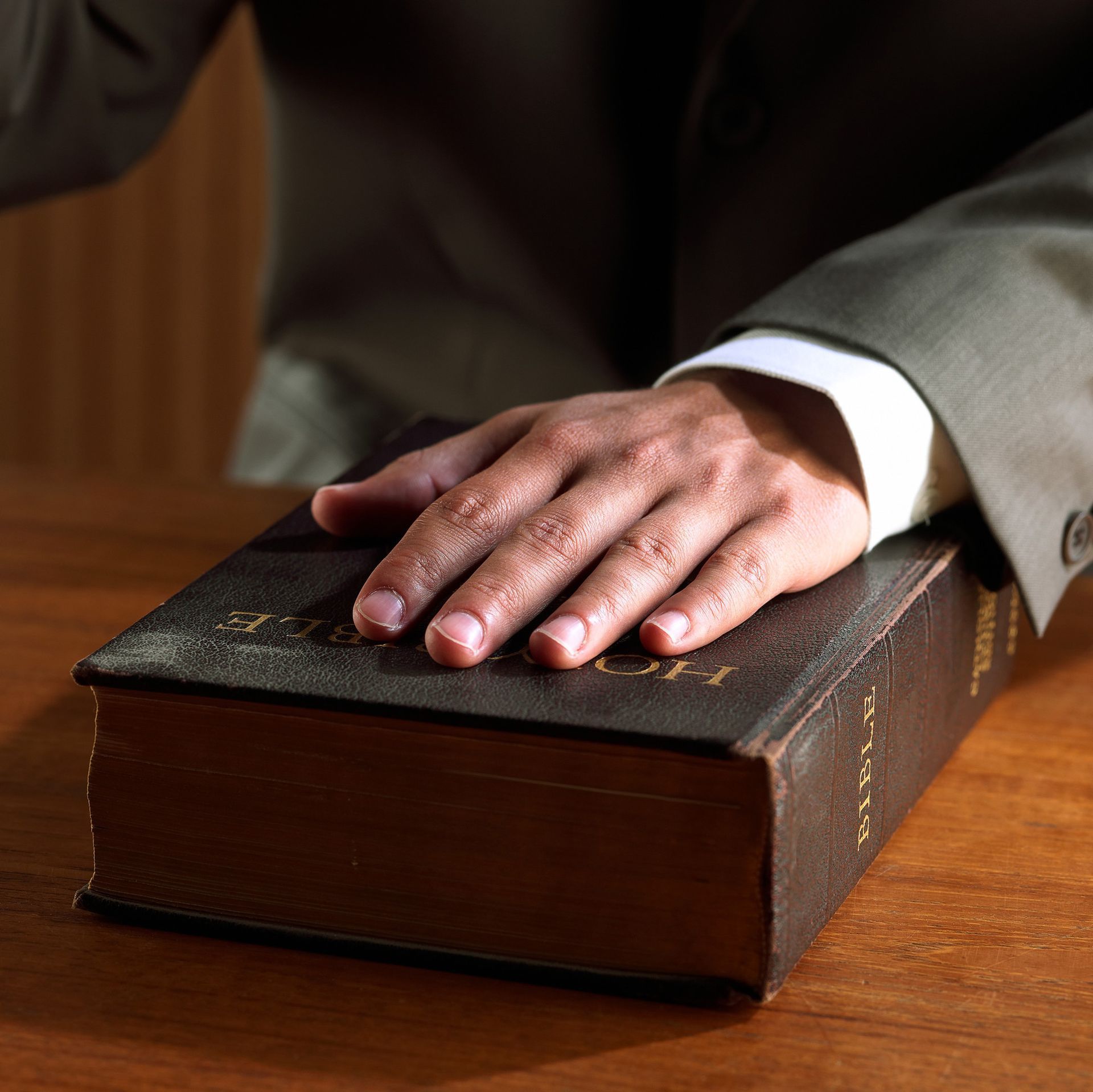 a man 's hand rests on top of a bible