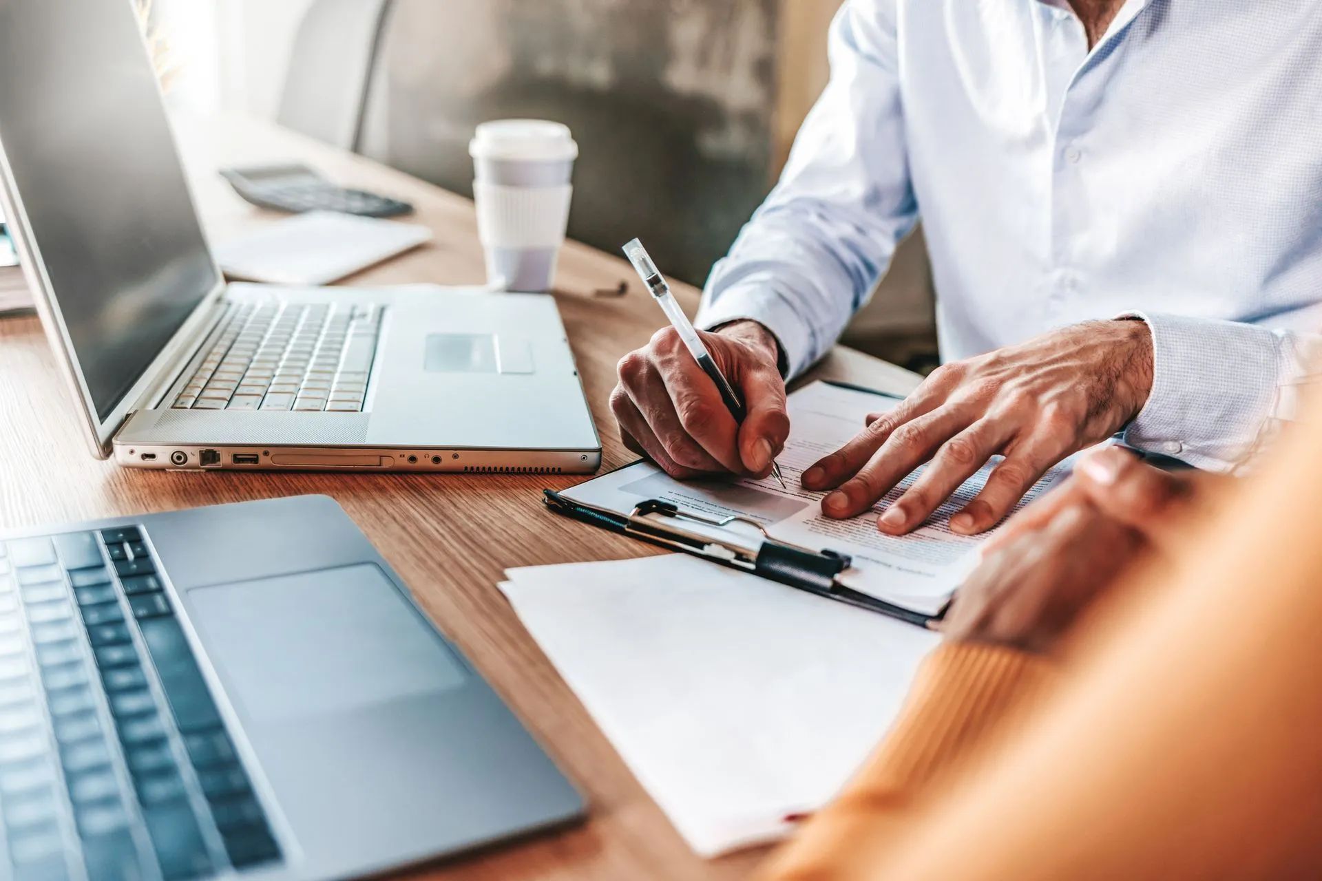 Insurance claims adjuster signing claim documents at an office desk
