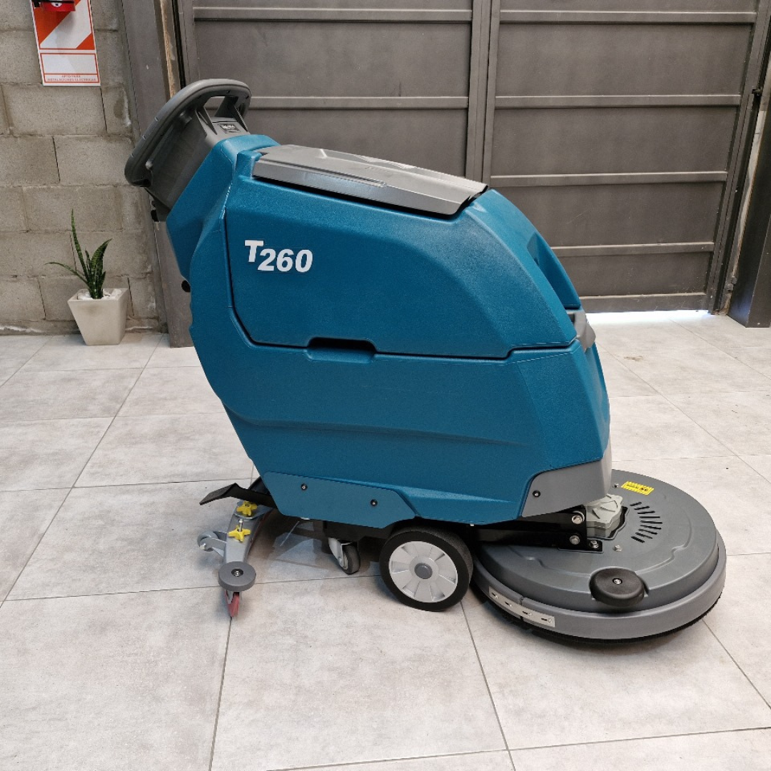 Máquina fregadora de suelos T260 de color azul sobre un suelo de baldosas grises, en el interior.