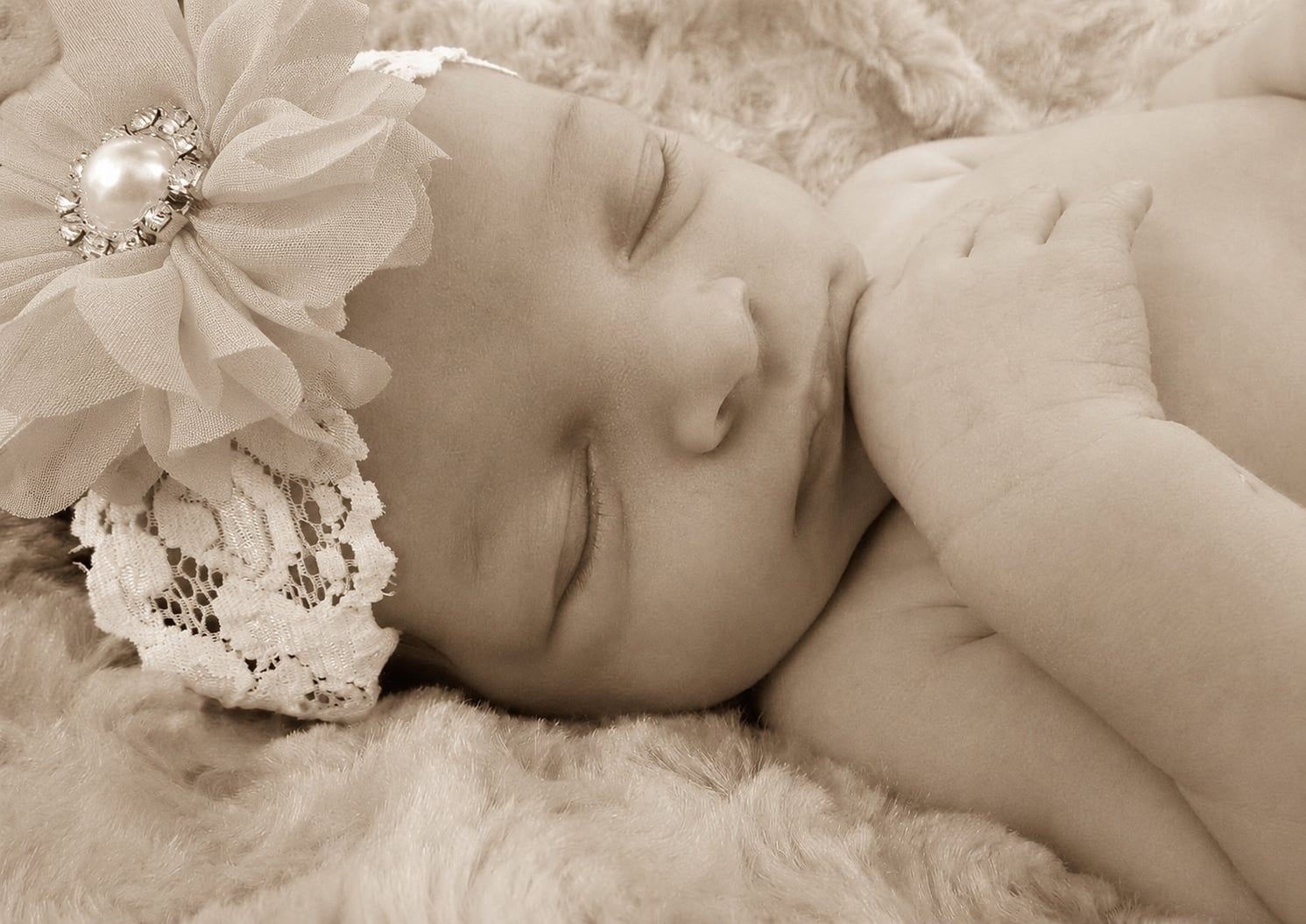 Sleeping newborn baby wearing a lace bonnet during a newborn portrait session in Newnan, GA