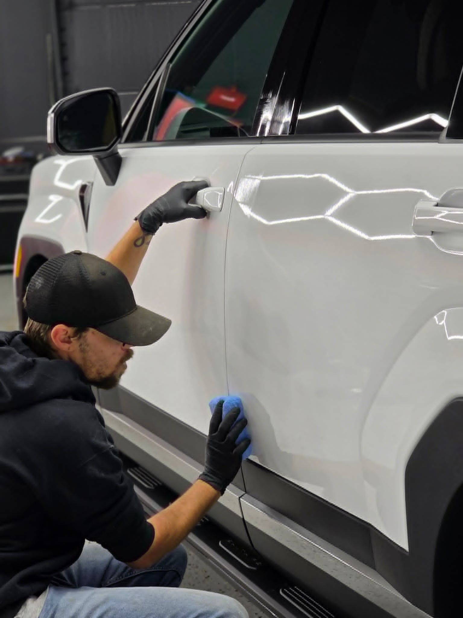 Professional photographer preparing a white car for a photoshoot