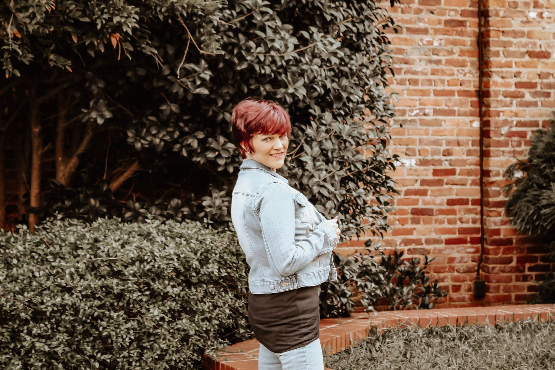 Woman with short red hair wearing a denim jacket posing for a professional headshot in Newnan, GA