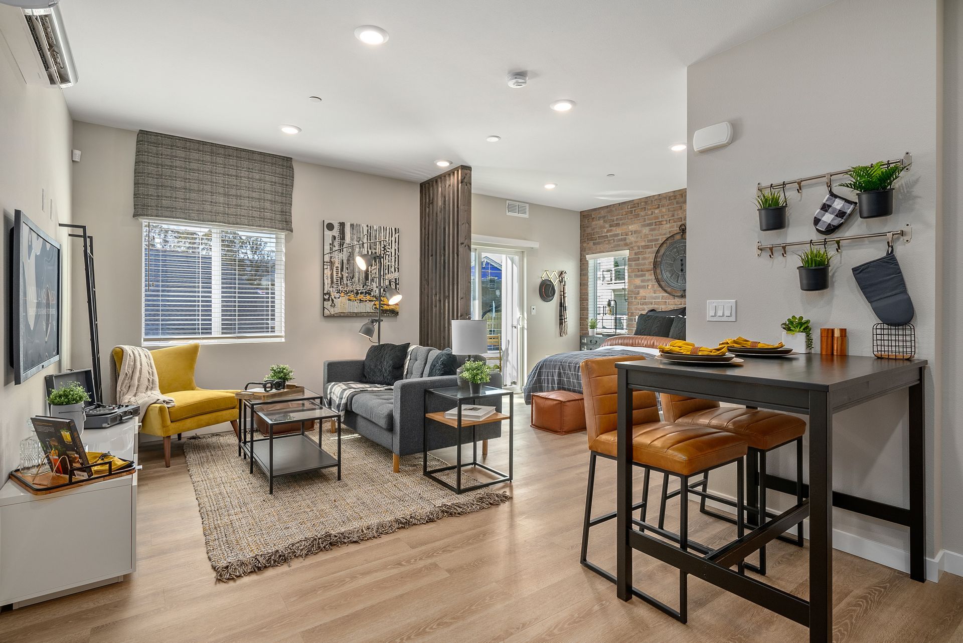 Living room with a dining area; neutral tones, modern furniture, and a window to the outside.