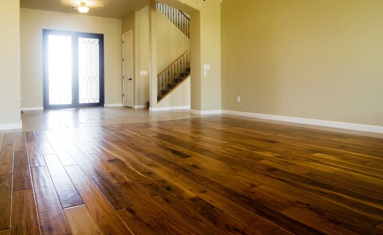 Una habitación luminosa y vacía con pisos de madera pulida