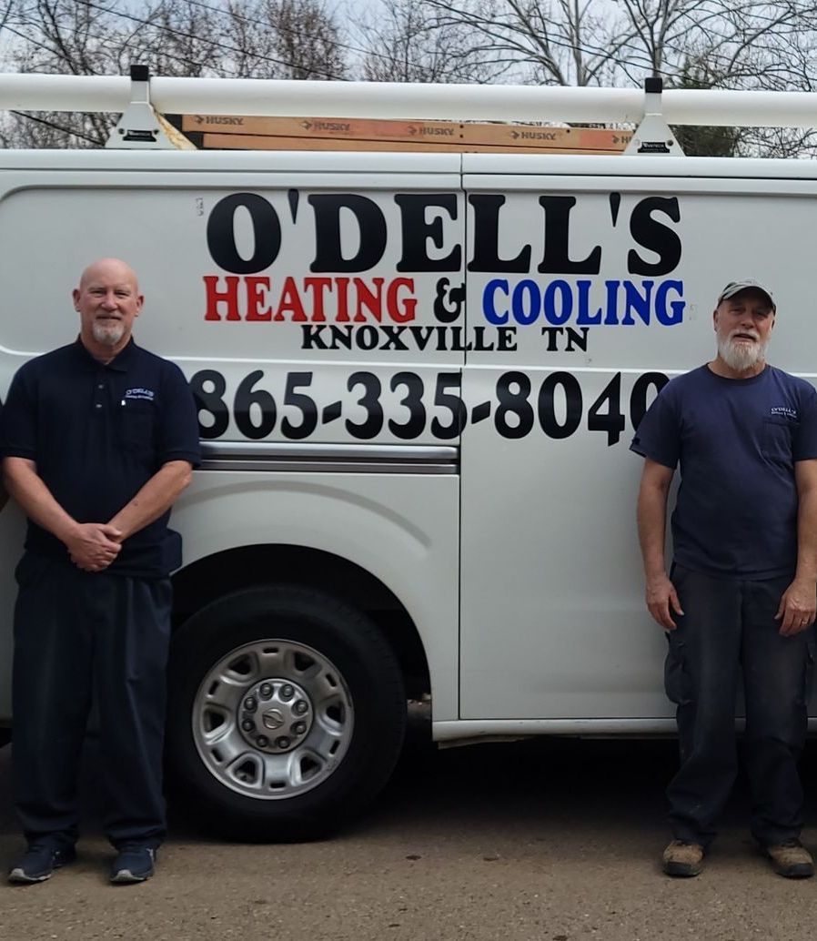Two men standing in front of a o'dell 's heating and cooling van