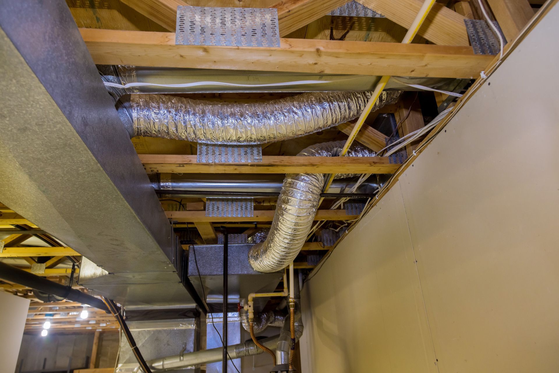 A ceiling with a lot of pipes coming out of it.