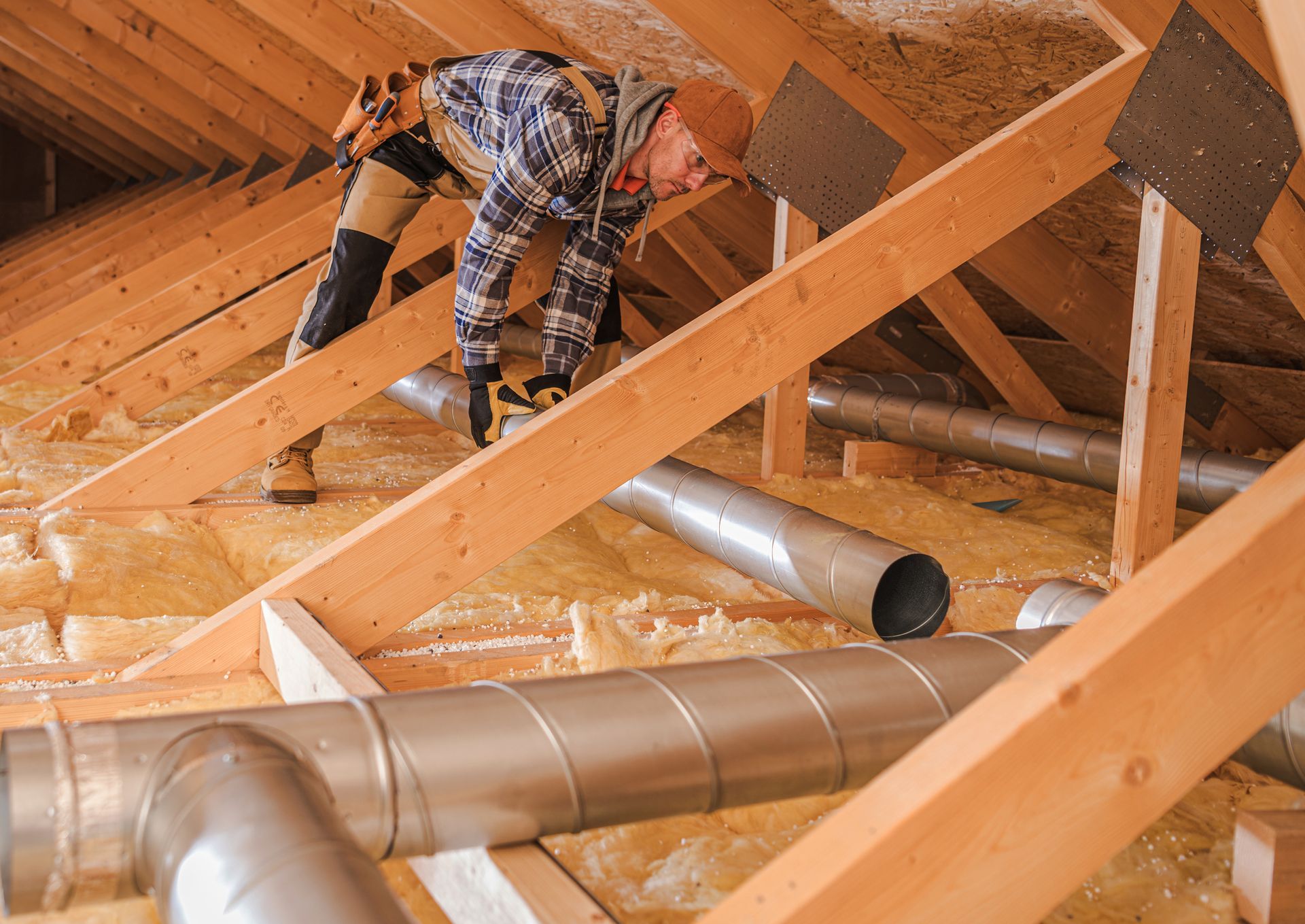 A man is working on the attic of a house.