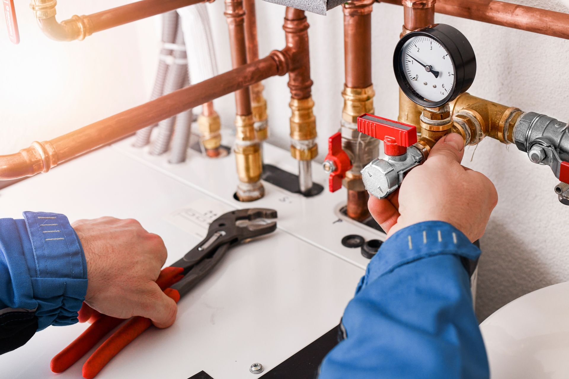 A plumber is working on a pipe with a wrench and a gauge.