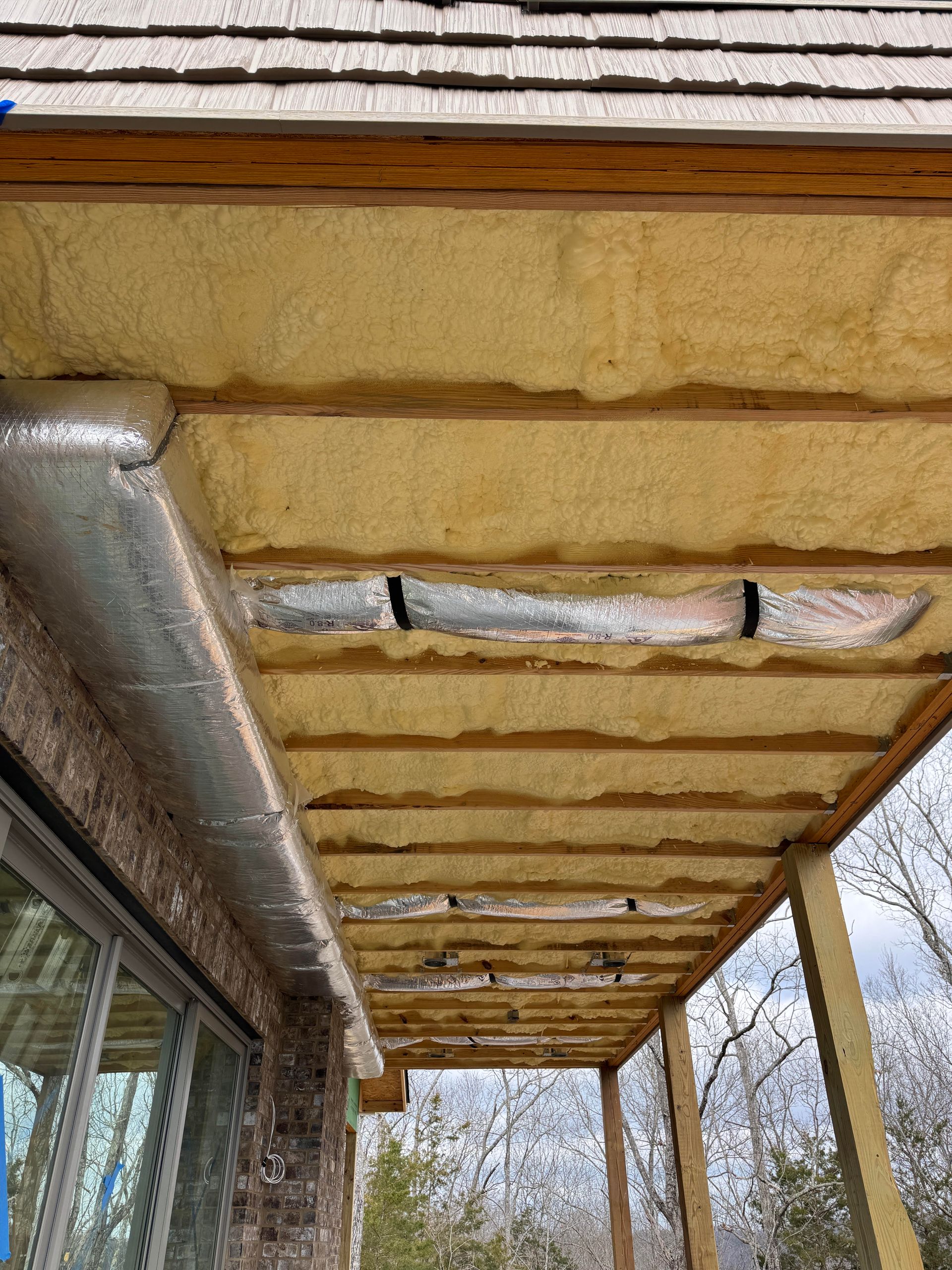 The ceiling of a building with a lot of insulation on it.