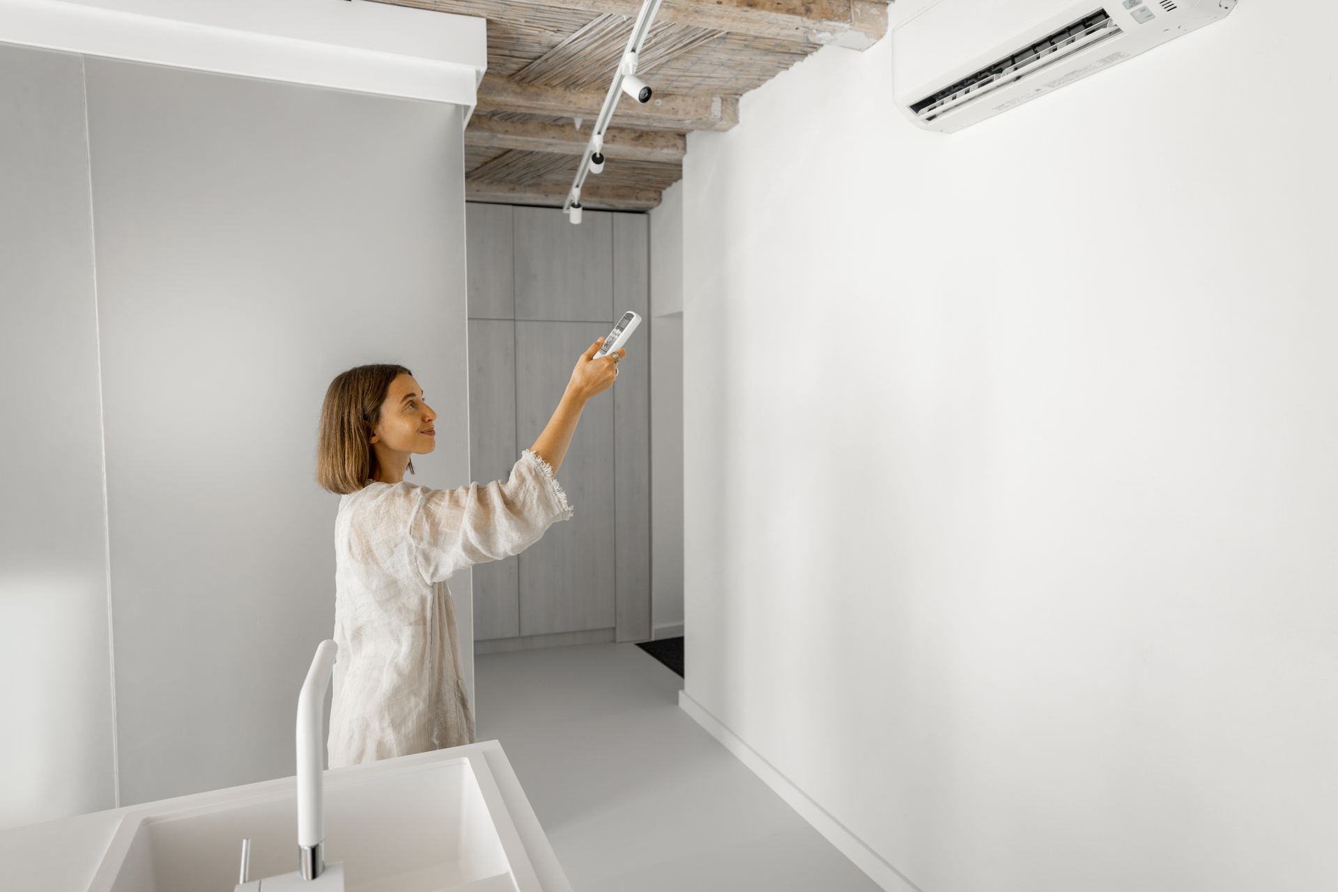 A white air conditioner is mounted on the side of a brick building.