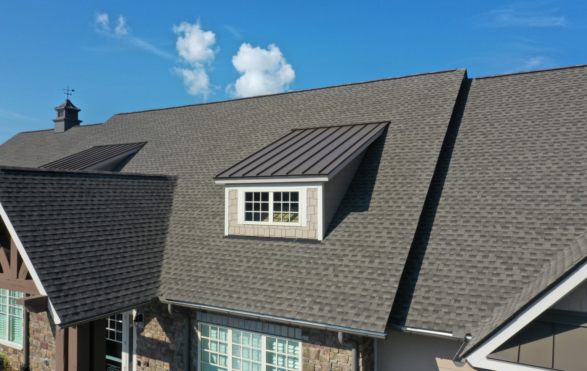 A house with a gray roof and a window on the roof.