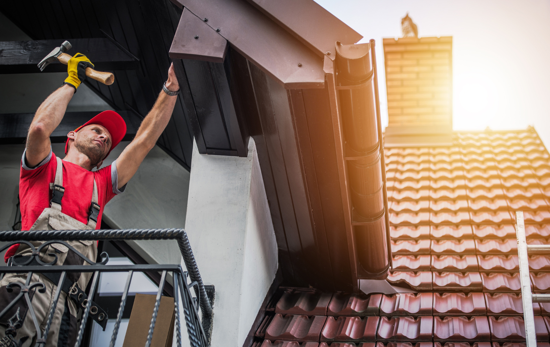 A man is working on a roof with a hammer.