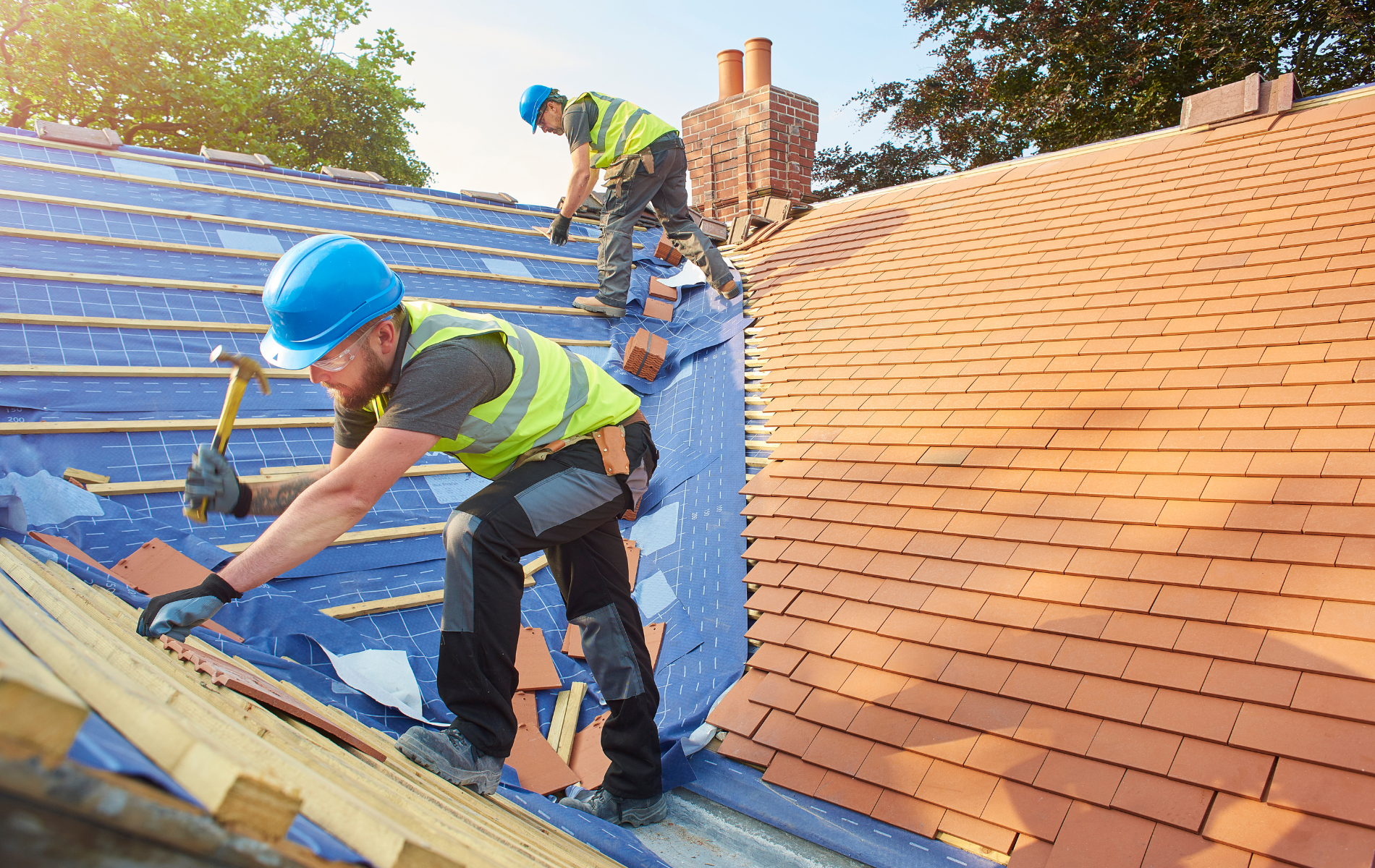Two men are working on the roof of a house.