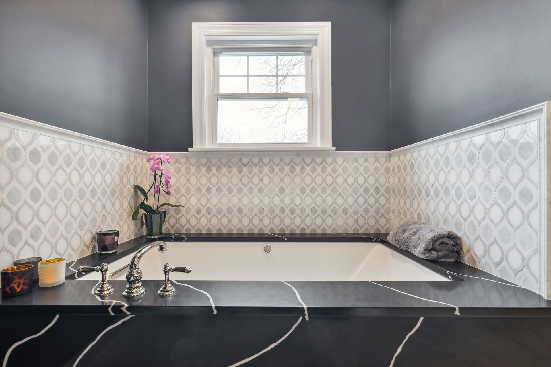 A bathroom with a large tub and a window.