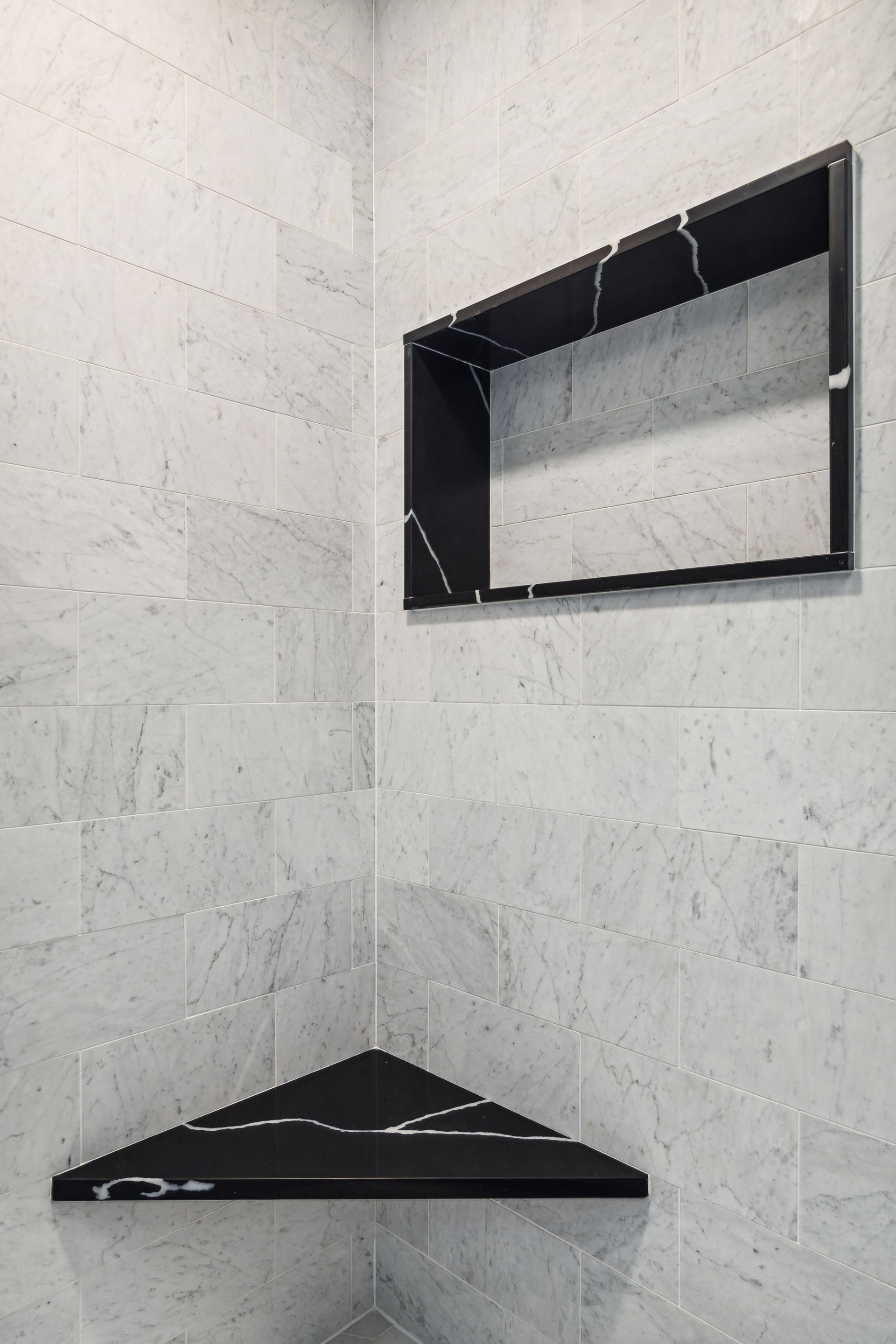 A bathroom with a corner shelf and a mirror on the wall.