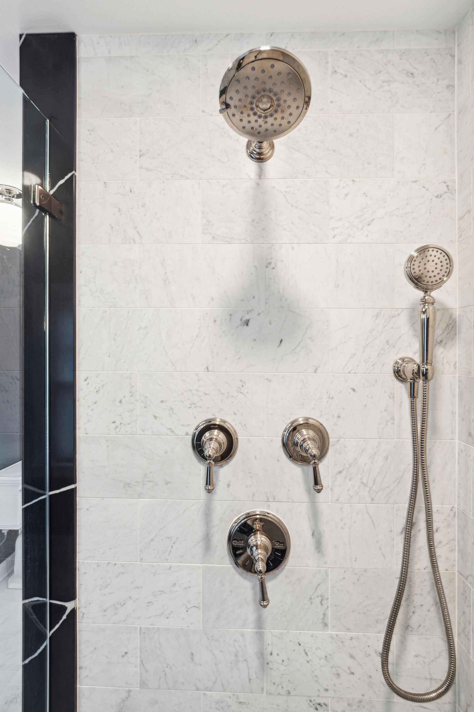A shower head is hanging from the ceiling in a bathroom.