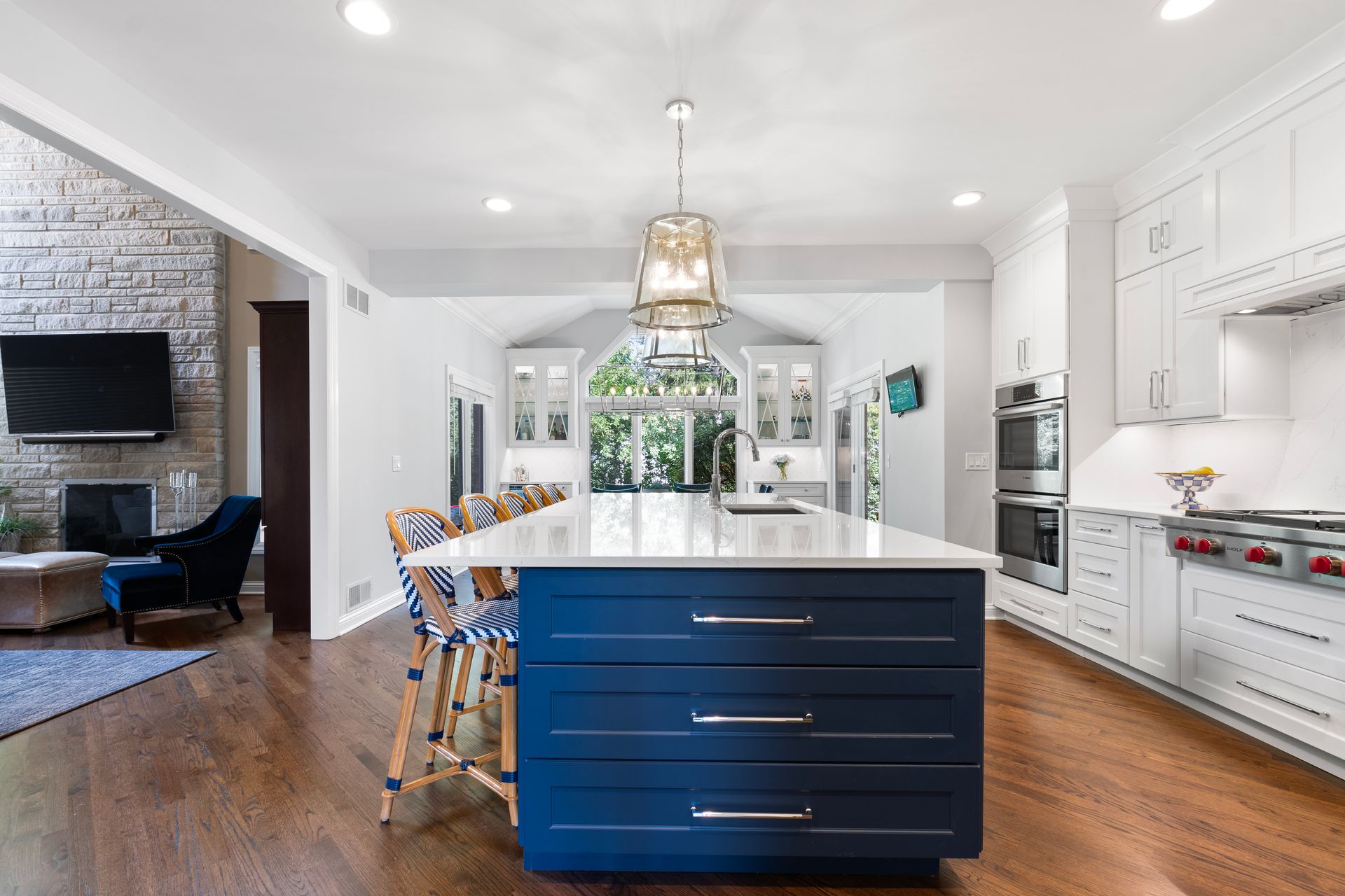 A kitchen with a large blue island and white cabinets.