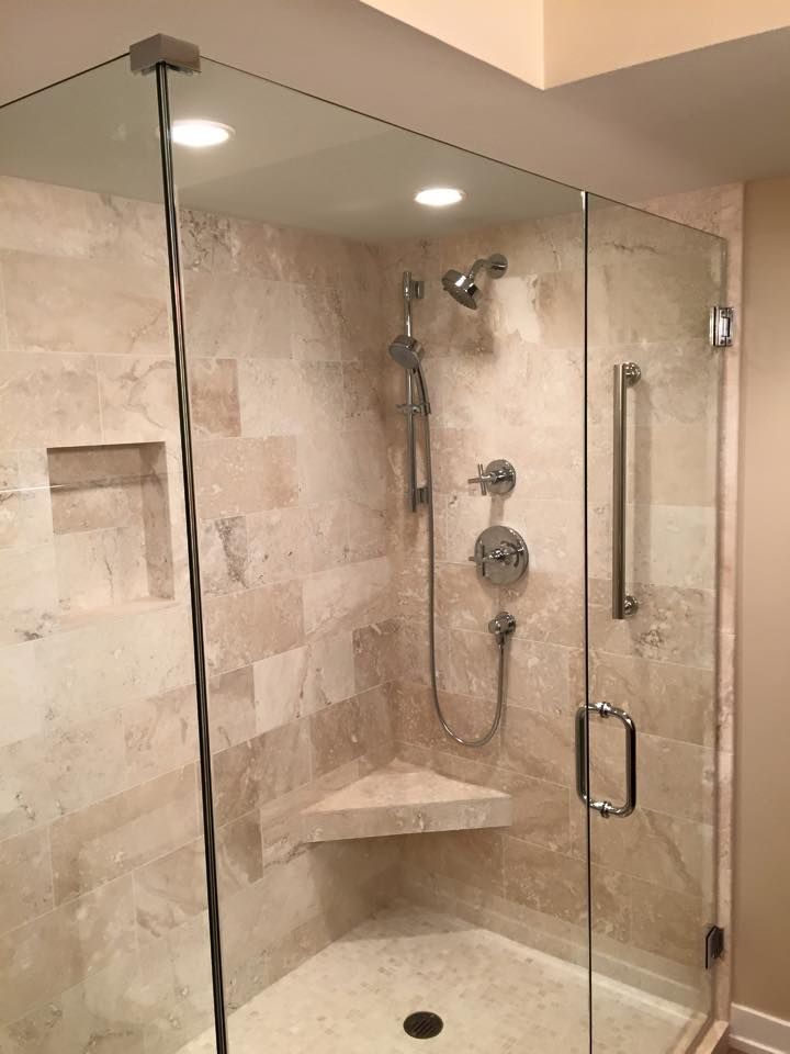 A bathroom with a walk in shower with a glass door.