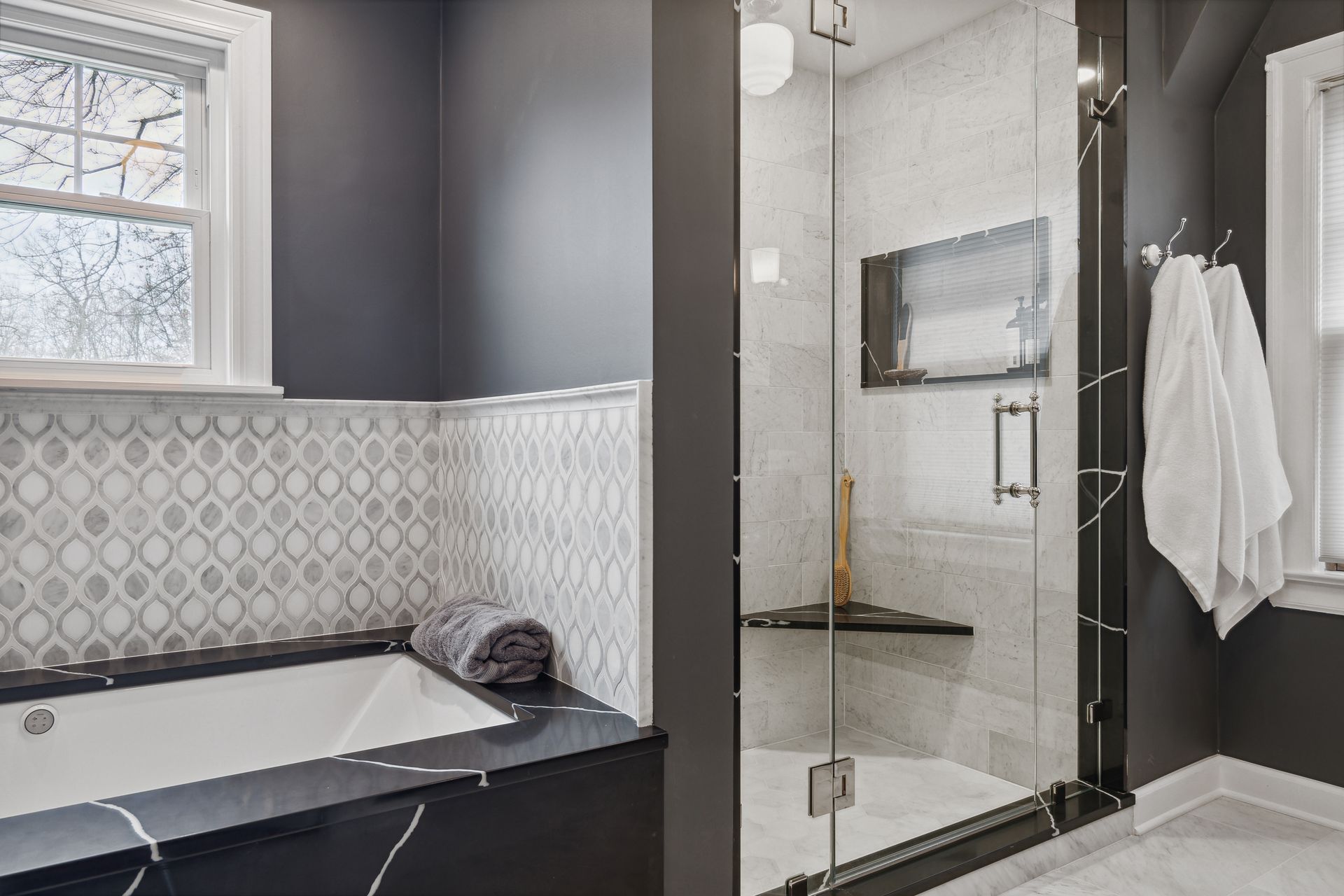 A bathroom with a tub , shower , and window.