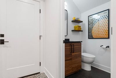 A bathroom with a toilet , sink , and picture on the wall.