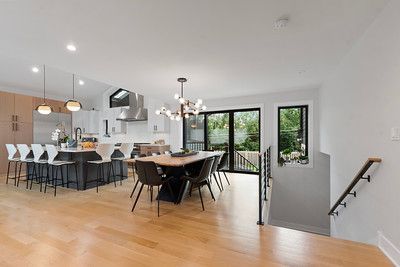A kitchen and dining room in a house with hardwood floors and stainless steel appliances.