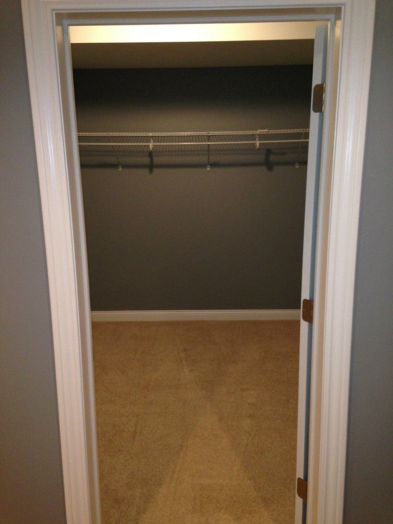 An empty walk in closet with a white door