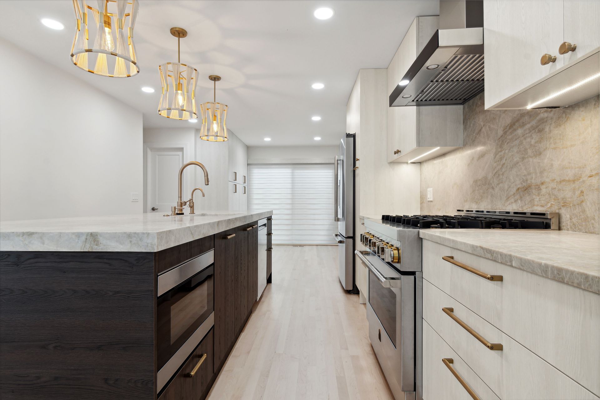 A kitchen with stainless steel appliances and a large island.