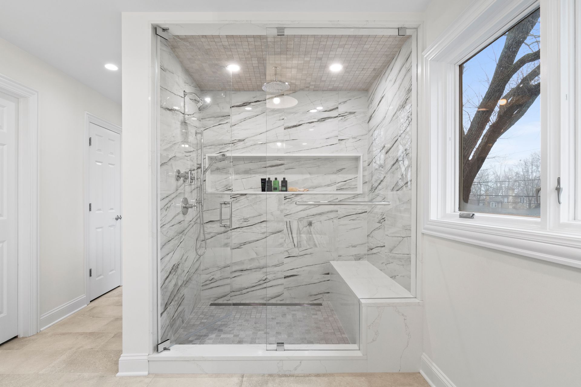 A bathroom with a walk in shower and a window.