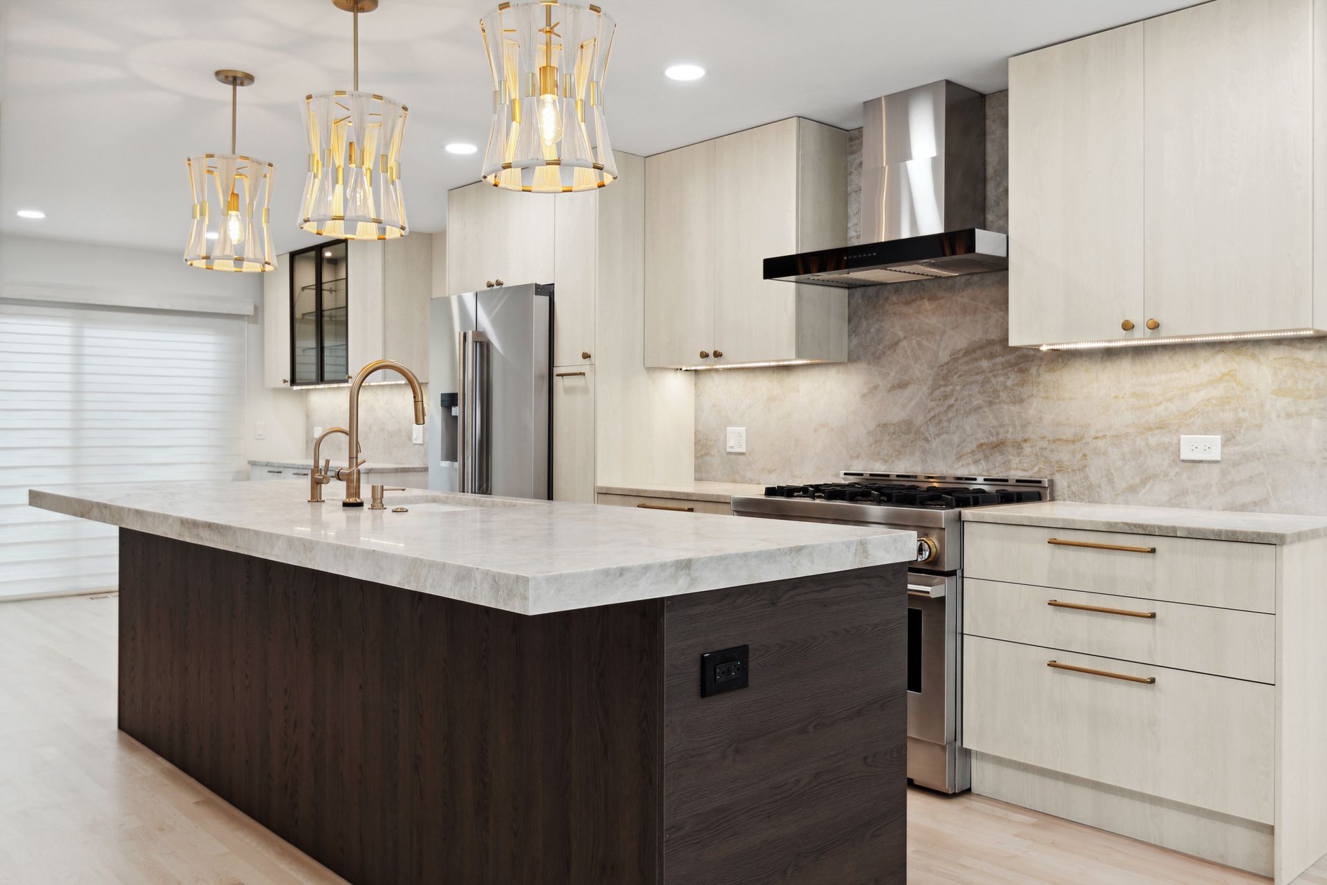 A kitchen with stainless steel appliances and a large island in the middle.