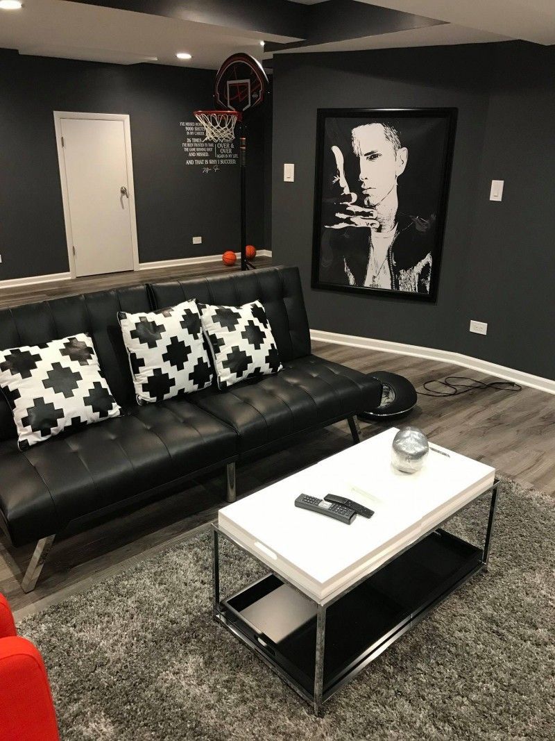A living room with a black couch and a white coffee table.