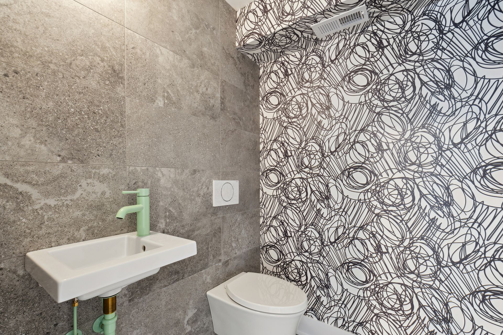 A bathroom with a toilet , sink and mirror.