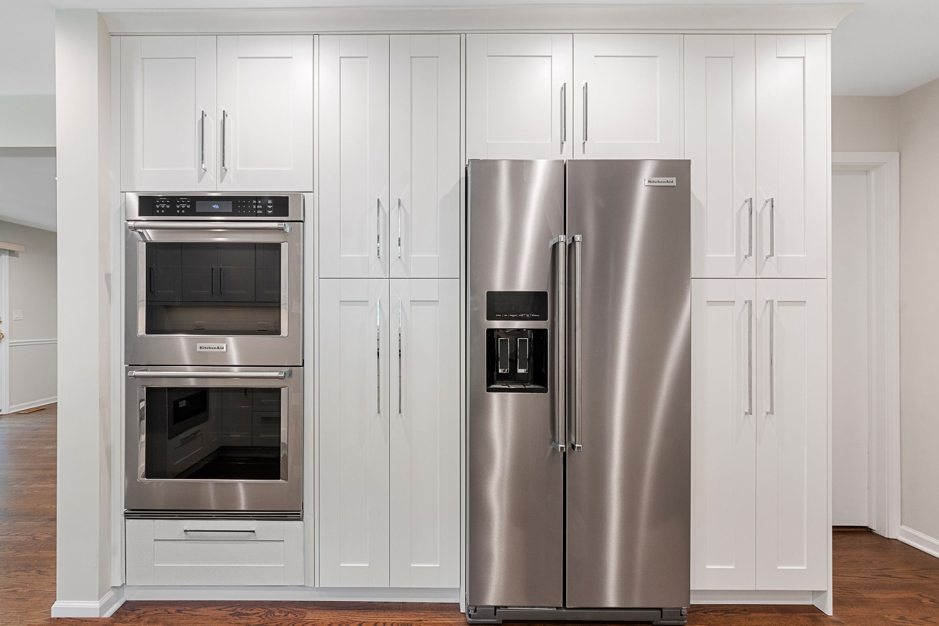 A kitchen with stainless steel appliances and white cabinets.