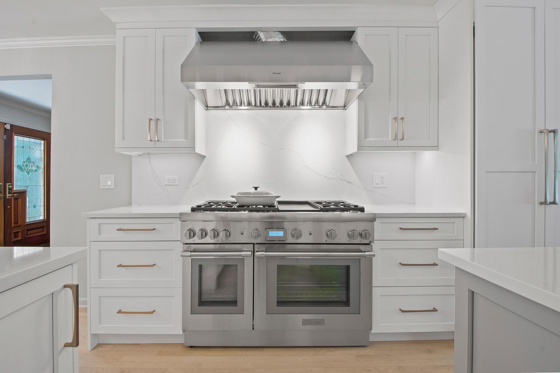 A kitchen with white cabinets and stainless steel appliances.