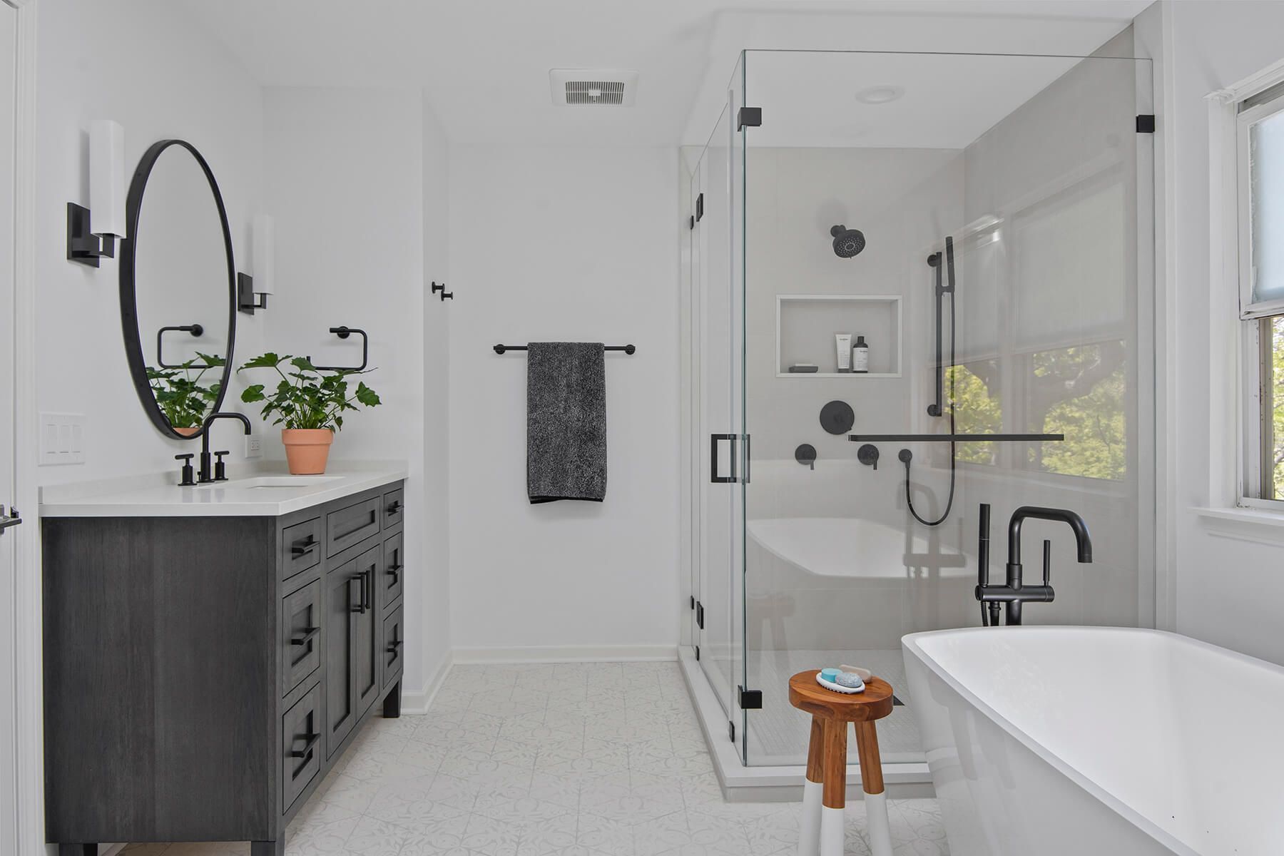 A bathroom with a tub , sink , mirror and shower.
