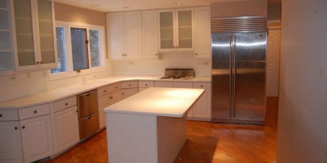 A kitchen with white cabinets and stainless steel appliances