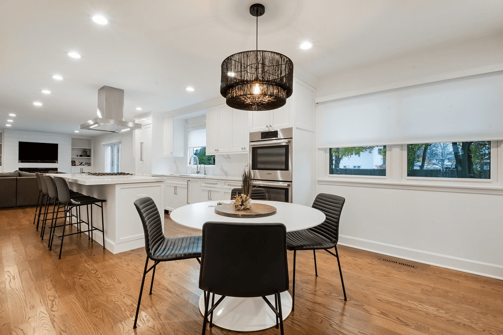 A dining room with a round table and chairs and a chandelier.