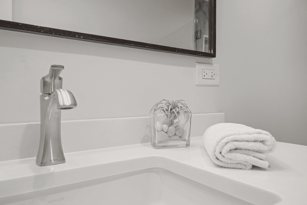 A bathroom sink with a towel on it and a mirror.