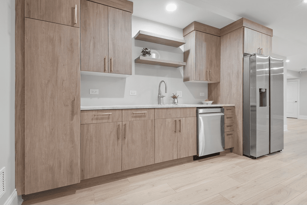 A kitchen with wooden cabinets , stainless steel appliances , and a refrigerator.