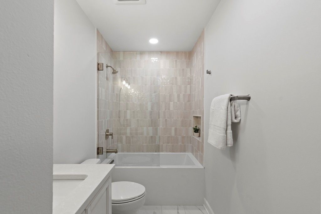 A bathroom with a tub , toilet , sink and shower.