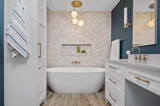 A bathroom with a bathtub , sink and mirror.