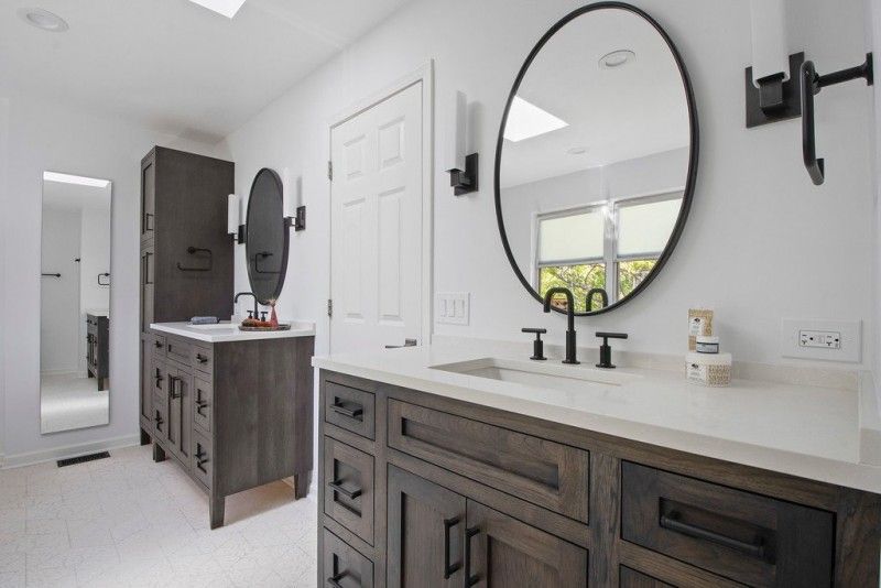 A bathroom with a sink , mirror and cabinets.