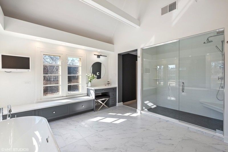 A bathroom with a bathtub , shower , and television.